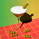 Cake cocktail with an olives candle on a red and green checkered tablecloth