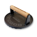 Cast iron burger press with wooden handle on a white background