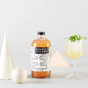 Bottle of Morris Kitchen ginger spice with a cocktail and decorative elements on a light background