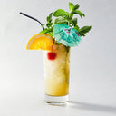 Cocktail with orange slice, cherry, and mint leaves on a white background