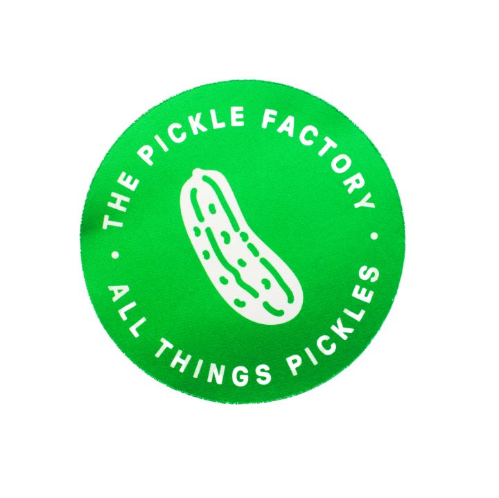 Green jar opener with a pickle design and text that reads 'The Pickle Factory All Things Pickles'