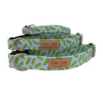 Three different sizes of blue dog collars with a pickle pattern on a white background