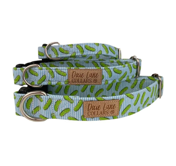 Three different sizes of blue dog collars with a pickle pattern on a white background