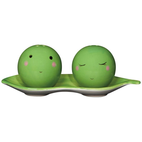 Two green ceramic peas with faces on a green plate against a white background