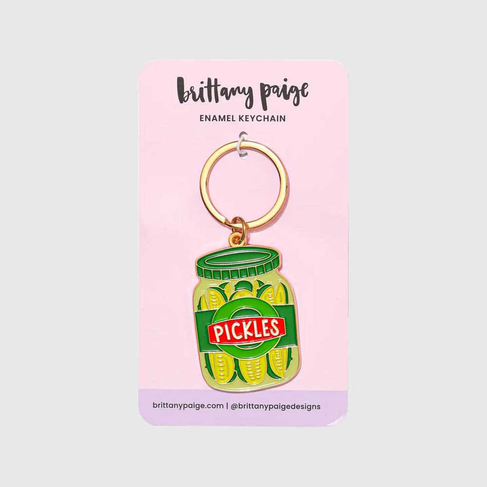 Enamel keychain of a pickle jar on a pink backer card with 'brittany paige' vendor branding.